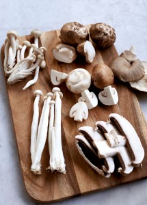 Variety of fresh mushrooms: white brown beech, button, shiitake, grey oyster, and portobello.